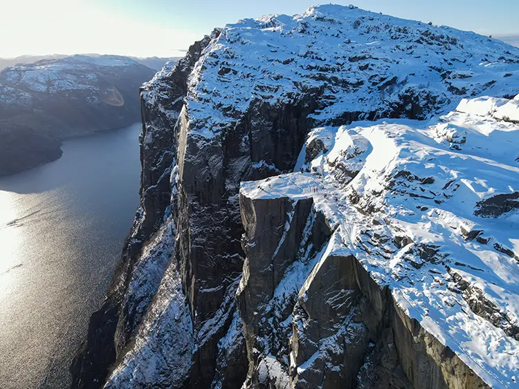 Snow-covered Preikestolen plateau and cliff above Lysefjord